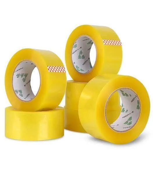 3 inch transparent packing tape rolls arranged in a stack showing yellow tint and inner paper cores on white backdrop