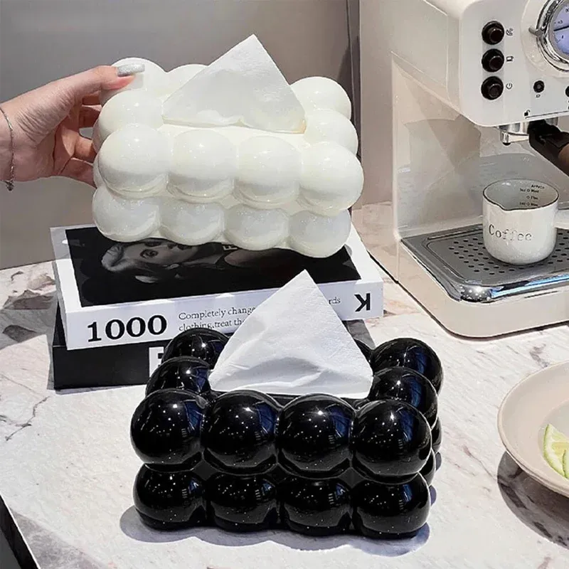 White and black Bubble Bow Tissue Box dispensers featuring bubble texture and small pink bows on tabletop surfaces.