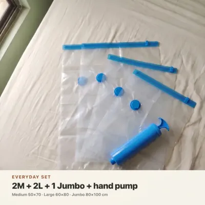 Set of five clear Vacuum Storage Bags in Pakistan spread on a white bed with a blue hand pump.